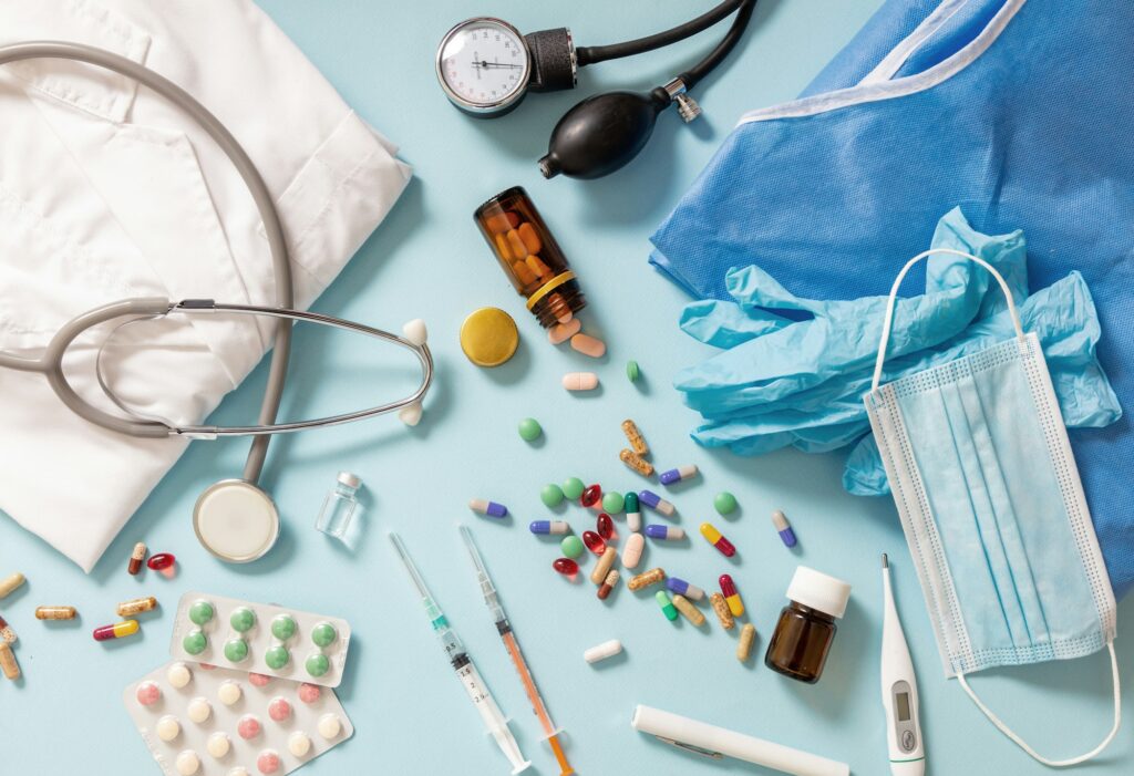 Judge gavel, medical stethoscope and medicine on a blue table.