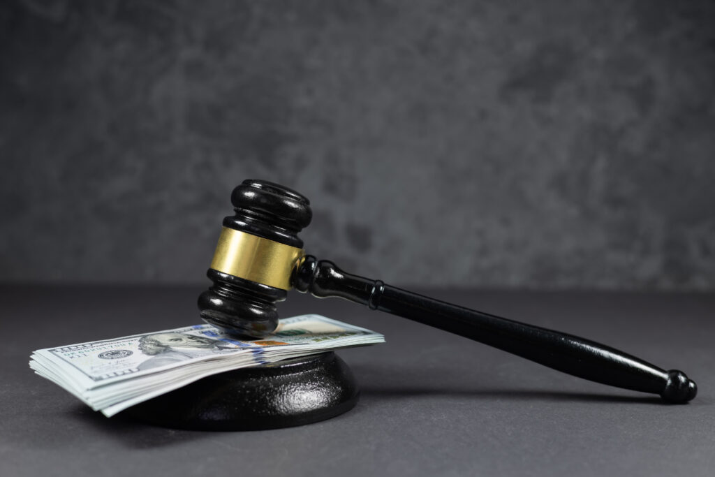 A gavel on top of hundred dollars bills.