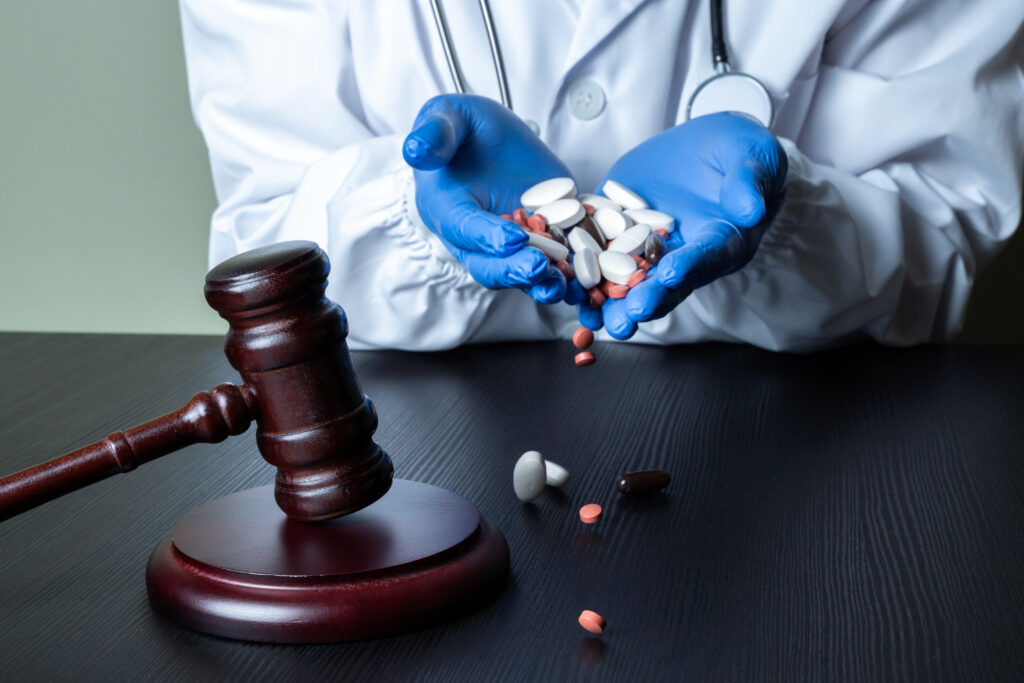Doctor holding multiple pill bottles and tablets.