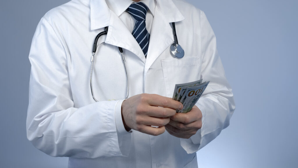 Doctor counting one-hundred-dollar bills.