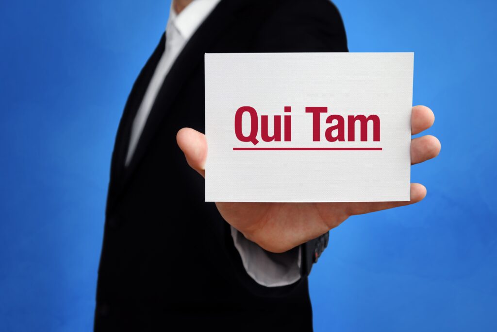 Lawyer in a suit holding up a card that says ‘Qui Tam.'