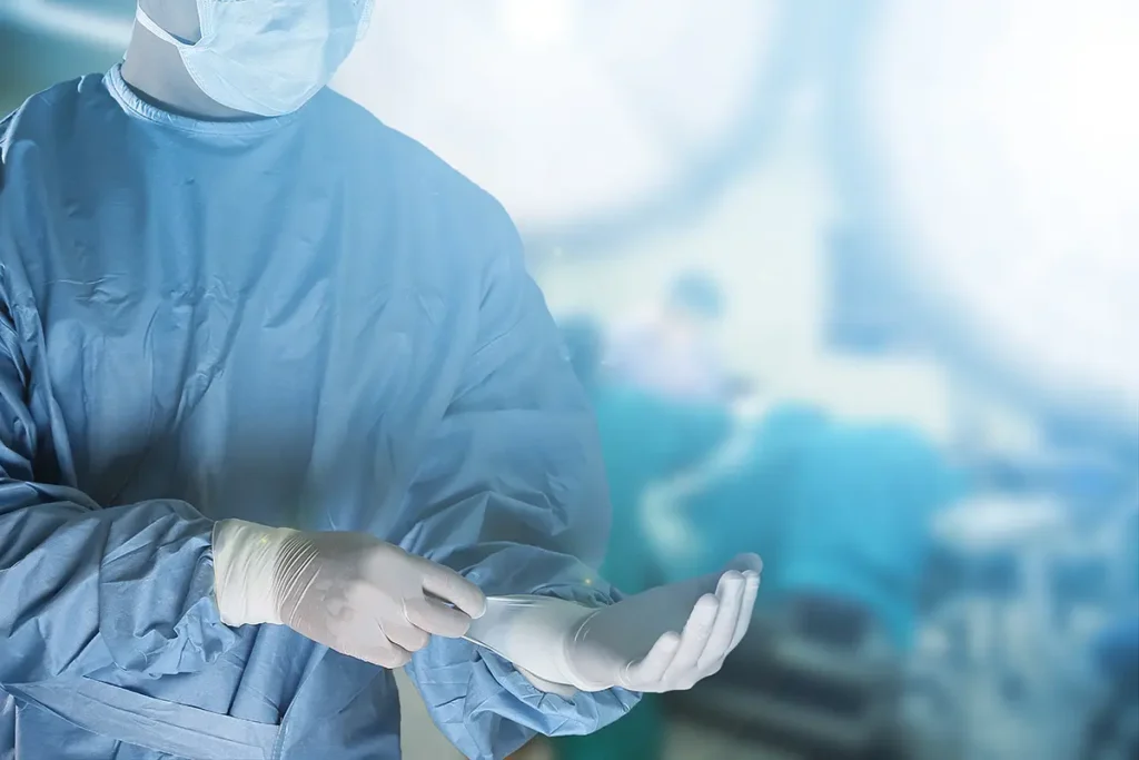 A doctor is preparing for surgery, scrubbing down and putting on gloves before starting a procedure. Healthcare fraud concept.